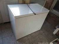 Photo of the white Frigidaire chest freezer showing top and side with power cord wrapped on top.