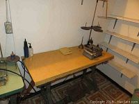 Overall view of Singer sewing machine on wood veneer table with metal base showing the setup and environment.
