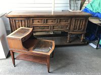 Vintage wooden sideboard with multiple drawers and cabinet doors, along with stepped coffee table featuring leather inset tops and small drawer on upper level.