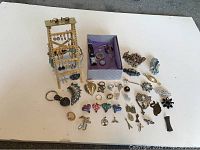 Overview of lot showing ladder stand with earrings, pendants and brooches on table