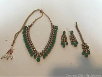 Photo of the full jewellery set including necklace, earrings, and headpiece laid flat on a white surface