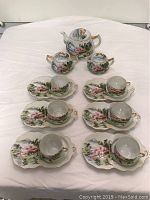 Complete tea service set arranged on table, showing teapot, creamer, sugar pot, 6 cups with matching luncheon plates.