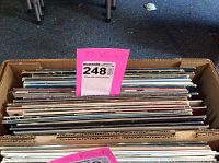 Full view of the box of vinyl records showing stacked albums from the 70s and 80s rock genre.