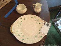 Oval Belleek Shamrock Ware plate with green shamrocks and woven texture, shown flat on table with lot number tag visible