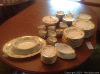 Full lot of Noritake china set displayed on wood table with various stacked plates and serving dishes