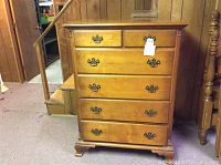 Front view of Kling tall dresser showing 6 drawers with brass-tone decorative handles and pulls.