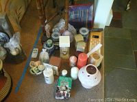 Wide view of all candles and accessories arranged on floor, showing variety and quantity in lot