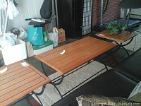 Set of three wood and metal tables including one coffee table and two side tables indoors next to couch, showing overall look and style.