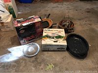 Photo shows boxed George Foreman grill, boxed Chinese wok set, roasting pan, small wire baskets and a United States Senate ashtray on floor.