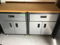 Front view of Gladiator storage system showing wood top, two drawers and two cabinets with diamond plate fronts