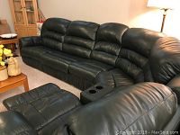 Front view of entire sectional showing left recliner, armless seats, center console and right recliner