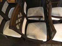 Six chairs grouped showing two armchairs and four side chairs with dark wood frames and light upholstery.