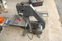 Side and front view of gray Durex 10-inch bench band saw showing motor, power switch, and ribbed work table with blade and guide.