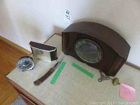 Overview of the lot showing three clocks and one knife on a surface.