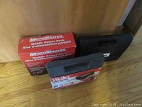 Photo of Motomaster Mobile Power Pack charger boxed next to Weller soldering gun case and their boxes on a wooden floor.