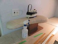 Small ironing board with Black and Decker iron and spray bottle on a surface