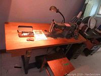 Full assembly: sewing machine head, wooden table, bench and accessories laid out