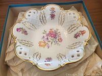 Top view of the bowl showing floral patterns, lattice cutouts, and gold trim