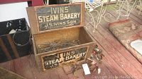 Front and open view of wooden Ivins' Steam Bakery box showing condition, paint, and contents inside with spurs and skates.