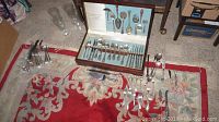 Vintage Reed and Barton flatware set displayed in wooden case and laid out on a carpet.