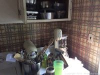 KitchenAid stand mixer with attachments, Mix N Whip milkshake machine, Cuisinart blender on kitchen counter with utensils and cups.