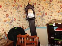 Full view of dark wood longcase clock in room