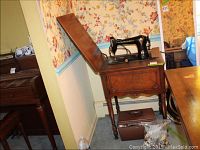 Full view of vintage Free Westinghouse sewing machine mounted on a wooden sewing table with hinged top, showing table and machine setup.