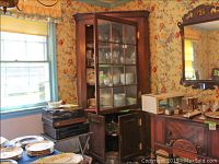 Front view of assembled mahogany corner cabinet with dishes inside display