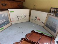 Four framed prints displayed together: two ship prints flanking two abstract tug-of-war prints.