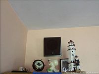 Photo showing lighthouse, peg-legged captain, Stellar barometer, and other nautical items together on a shelf against a wall.
