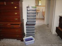 First photo showing two stacked black plastic storage racks with six translucent drawers each beside a wooden dresser. Three plastic baskets on the floor in front of racks.