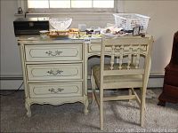 Front view of the French provincial desk and matching chair showing overall condition and items on desk surface.