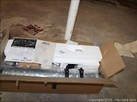 Opened box showing styrofoam packaging with telescope parts and tripod.