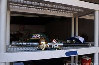 Overview of lot showing vintage baseball bat, brass Mr. Potato Head figurine, small decorative house with number 152, toy car, and blue trucker hat