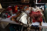 Overview of the selection including gloves, cotton mop heads, cleaning brushes, and red gas cans on a table in garage or storage area.