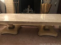 Full view of rectangular marble top coffee table resting on carpeted floor, showing the cream marble surface and base.