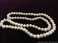 Close up of white fresh water pearls showing slight irregularities in pearl shapes and shine on black background