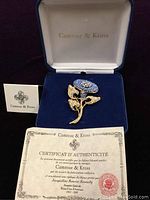 Brooch in jewelry box with certificate of authenticity showing