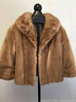 Front view of Eaton's mink fur jacket on mannequin, showing plush light tan fur and boxy shape.