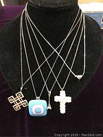 Front view of 5 sterling silver necklaces displayed on black jewelry bust showing all pendants