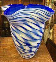 Front view of the large blue and white swirl glass vase with wavy top edge