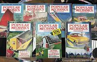 Lot of 7 Popular Mechanics magazines from 1957 showing all front covers with various mechanical and automotive themed illustrations.