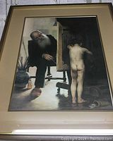 Full image of framed print showing elderly man painting nude child in an artist studio