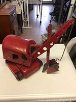 Side angle view showing full toy steam shovel with bucket and treads