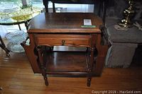 Front view of the wood end table showing the drawer and lower shelf.