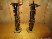 Pair of large heavy glass candlesticks with segmented bubble design, side view showing height and structure.
