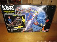 Front of the K'NEX Thunderbolt Strike Roller Coaster box showing the completed roller coaster and details about size and motor.