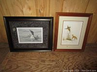 Photo showing two framed animal prints; left black and white loon print, right color pheasant and fox print