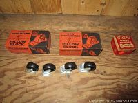 Four small castor wheels and two GM pillow blocks in boxes with an additional small red box