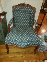 Front view showing fabric pattern and carved wood frame